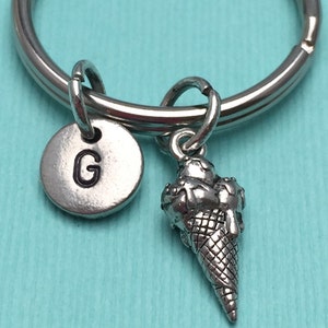 May include: Silver keychain with a letter G charm and a silver ice cream cone charm.