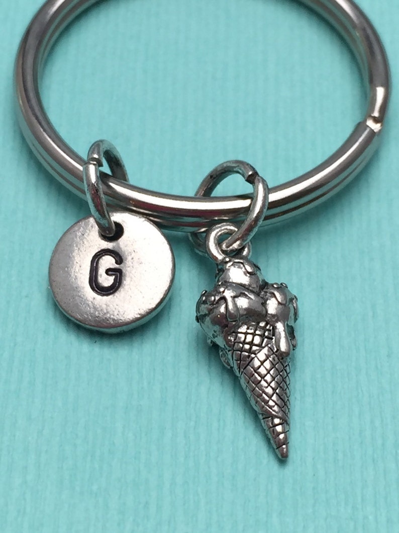 May include: Silver keychain with a letter G charm and a silver ice cream cone charm.