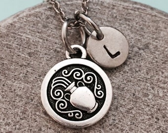 May include: Silver necklace with a charm featuring the astrological symbol for Aquarius, a water pitcher pouring water, and a small charm with the letter L.