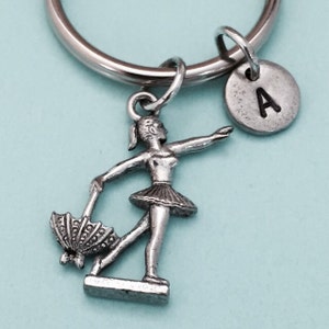 May include: Silver keychain with a ballerina charm holding an umbrella and a silver charm with the letter A.