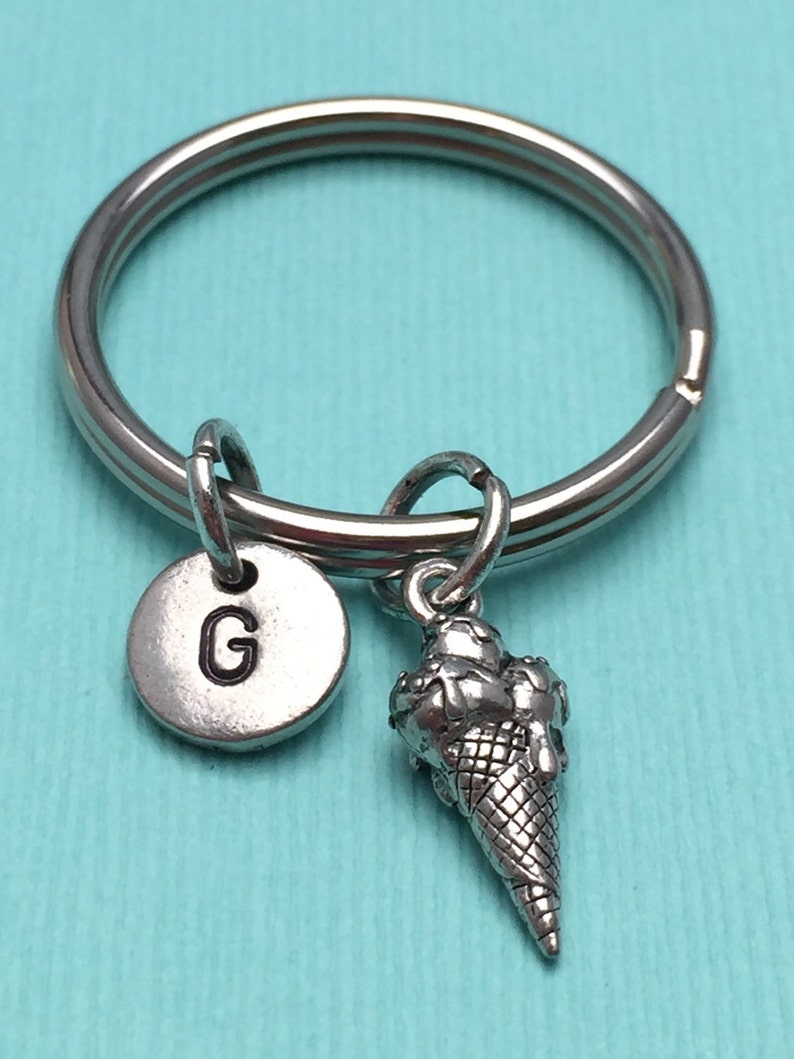May include: Silver keychain with a letter G charm and a silver ice cream cone charm.