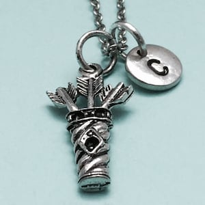 May include: Silver necklace with a charm of three arrows in a quiver and a silver charm with the letter C.