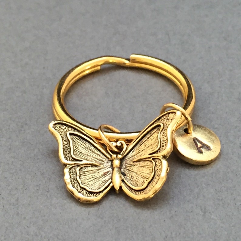 May include: Gold butterfly keychain with a gold letter 'A' charm.
