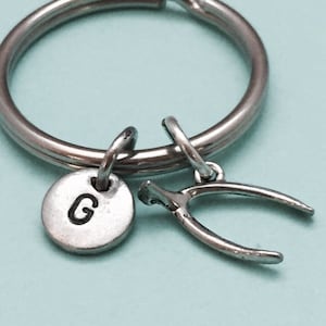 May include: Silver key chain with a letter G charm and a horseshoe charm.