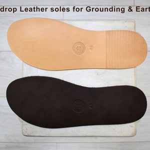 May include: Two leather soles for grounding and earthing. The top sole is light brown and the bottom sole is dark brown. Both soles have a textured surface and a size label.