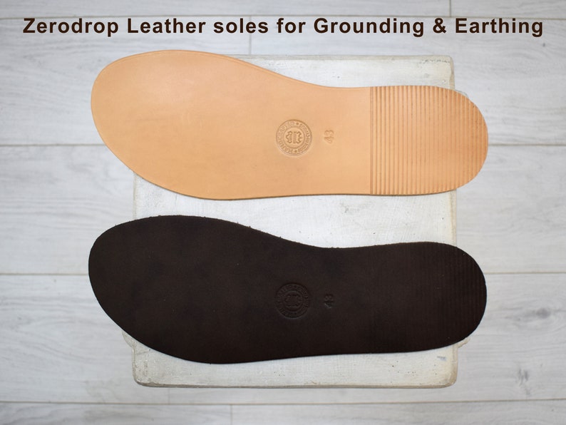 May include: Two leather soles for grounding and earthing. The top sole is light brown and the bottom sole is dark brown. Both soles have a textured surface and a size label.