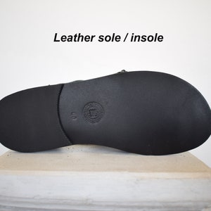 May include: Black leather sandal sole with a textured surface. The sandal sole is size 40. The text "Leather sole / insole" is above the sandal.