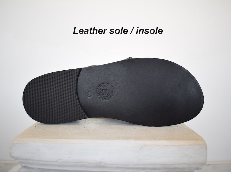 May include: Black leather sandal sole with a textured surface. The sandal sole is size 40. The text "Leather sole / insole" is above the sandal.