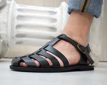 May include: Black leather sandals with a woven design and a buckle closure.