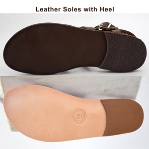 May include: Close-up of the leather soles of a sandal. The soles are brown and have a textured pattern. The sandal has a heel.