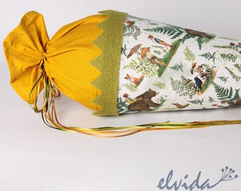 May include: A yellow fabric bag with white polka dots and a green felt trim. The bag is tied with a green and yellow ribbon. The bag is decorated with a white fabric panel featuring a woodland scene with animals, trees, and mushrooms.