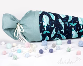 May include: A teal blue fabric cone with a white ribbon and a whale print. The cone is surrounded by small, colorful crocheted balls.