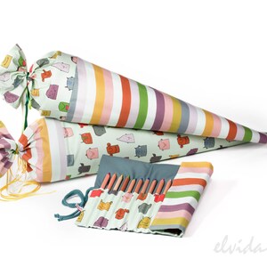 May include: Two colorful striped fabric cones and a matching pencil roll with a green background and cartoon faces. The cones are tied with yellow ribbon and the pencil roll has a blue zipper.