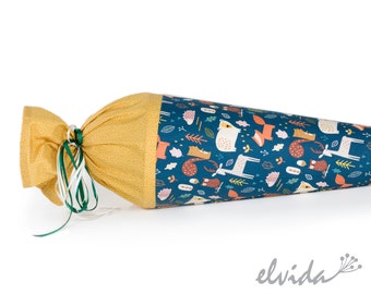 May include: A fabric school cone featuring a teal background with a pattern of forest animals in orange and white. The cone is tied with green and white ribbons and has a mustard yellow top with a small dot pattern. Designed for school children.