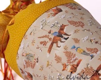 May include: A yellow fabric bag with a white and brown print of foxes, birds, and leaves. The bag has a yellow polka dot pattern on the top.