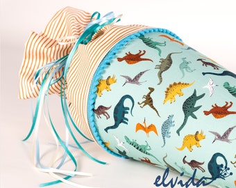 May include: A blue and white fabric cone with a dinosaur pattern. The cone has a brown and white striped fabric top with a blue ribbon.