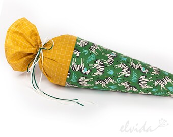 May include: A green and yellow fabric cone with a zebra print and a yellow checkered top. The cone is tied with a white and green ribbon.