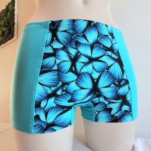 May include: Blue and black patterned underwear with a side panel of solid blue fabric. The pattern features a repeating design of blue butterflies.