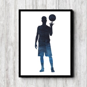 May include: A watercolor silhouette of a basketball player in blue and black, holding a basketball in their right hand.