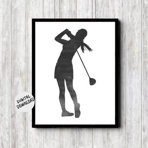 printable wall art of a female golfer silhouette in a grungy charcoal watercolor. she is standing in the position of a golfer after teeing off with the club over her shoulder