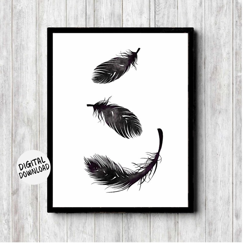 printable wall art of three black watercolor feathers that looks like they are falling