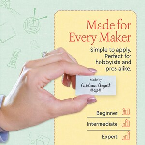 May include: A rectangular white fabric label with black text that reads Made by Carolann August, featuring a decorative flourish below the name. The label is presented against a light yellow background with text Made for Every Maker.