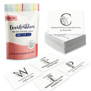 May include: A package of pre-cut cotton labels with the text "EverEmblem" and "Set of 12". The labels are white with black text and floral designs. Some labels have the text "Handmade With Love" and various names.