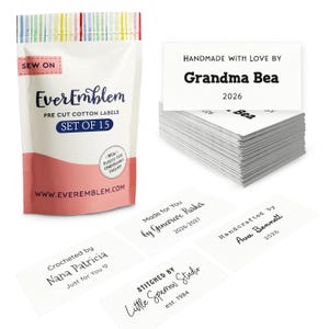 May include: A package of pre-cut cotton labels from EverEmblem, with the text "SET OF 15". Several individual labels are also visible, with text such as "Handmade with love by Grandma Bea 2026" and "Crocheted by Nana Patricia".