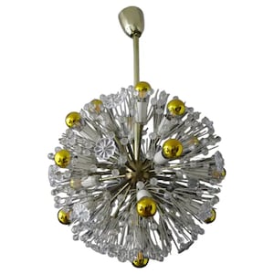 May include: A mid-century modern chandelier with a brass finish and clear glass crystals. The chandelier has a spherical shape and features multiple light bulbs.