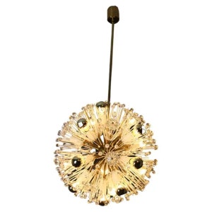 Peut inclure: Un lustre doré rond de forme sphérique. Le lustre est en verre transparent et comporte un grand nombre de petits cristaux pointus qui s'étendent vers l'extérieur depuis le centre. Le lustre est suspendu à une seule tige fine.