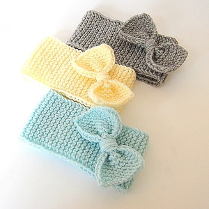 May include: Three knitted headbands with bows. The headbands are in light blue, yellow, and grey.