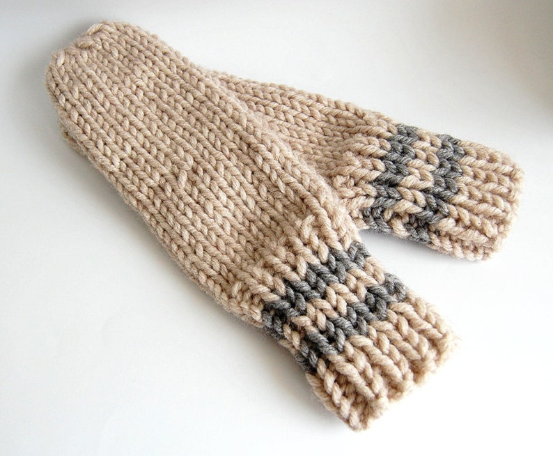 May include: A pair of beige knitted fingerless gloves with gray knit accents at the cuffs.