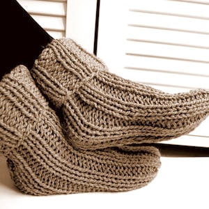 May include: A pair of brown knitted slipper socks with a ribbed texture.