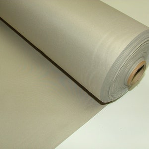 May include: A roll of light beige fabric, rolled up on a cardboard core. The fabric is smooth and has a slight sheen.
