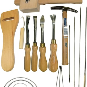 Puede incluir: Un conjunto de herramientas para trabajar el cuero que incluye un mazo de madera, un martillo, un desbastador de cuero, cuatro punzones para coser cuero, cuatro agujas para coser y tres herramientas de pony para coser. Las herramientas están hechas de madera y metal.
