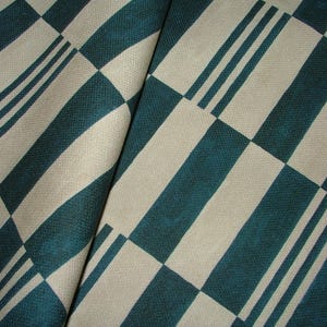 Può includere: Un tessuto con un motivo a scacchi in verde acqua e beige. Il tessuto ha una texture sottile ed è piegato a metà.