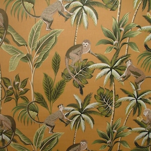 May include: A brown and green tropical print fabric featuring monkeys swinging from palm trees. The fabric has a repeating pattern of monkeys, palm trees, and leaves.
