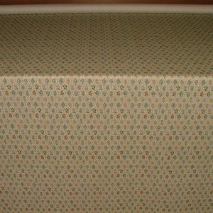 May include: A roll of fabric featuring a repeating pattern of small floral and leaf motifs in green, red, and blue on a cream background. The fabric is folded over a surface.
