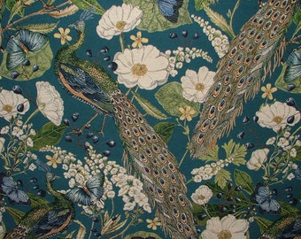 May include: Teal fabric with a repeating pattern of peacocks, butterflies, and white flowers. The peacocks have green and blue feathers and are depicted in a stylized manner.