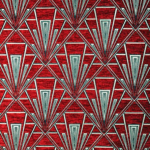 Op de afbeelding: Rode stof met een geometrisch patroon van witte en teal lijnen die een herhalend waaiervorm vormen.