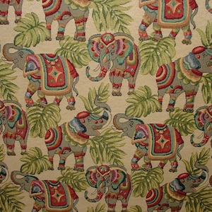 May include: A beige fabric with a repeating pattern of colorful elephants and green leaves. The elephants are decorated with intricate patterns and colors.