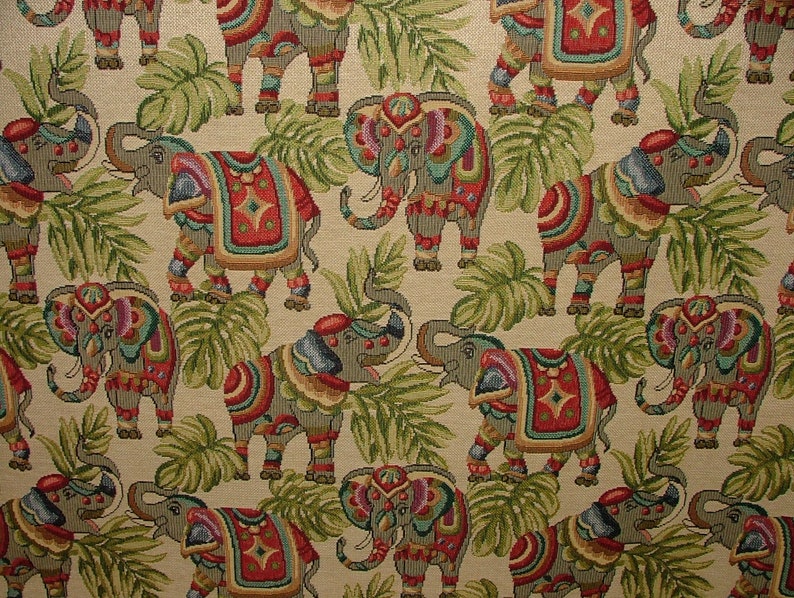 May include: A beige fabric with a repeating pattern of colorful elephants and green leaves. The elephants are decorated with intricate patterns and colors.