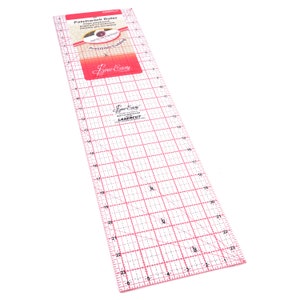 Puede incluir: Una regla de patchwork de plástico transparente con marcas rojas. La regla mide 61 cm de largo y tiene un patrón de cuadrícula con líneas diagonales. La regla está etiquetada como "Sew Easy" y "Lasercut".