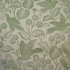 May include: A cream-coloured fabric featuring a repeating pattern of green birds, leaves, and flowers. The design includes stylized birds in flight amidst detailed foliage and floral elements, creating a nature-inspired aesthetic.