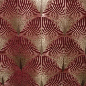 May include: A red fabric with a gold geometric pattern of overlapping fan shapes.