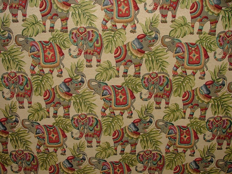 May include: A beige fabric with a repeating pattern of colorful elephants with intricate designs. The elephants are surrounded by green leaves.