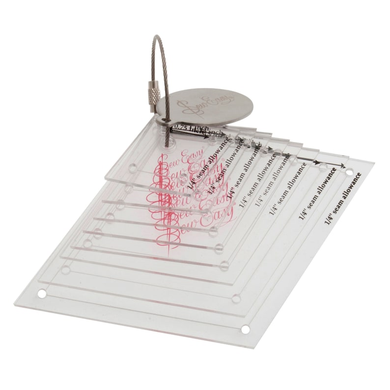Puede incluir: Un juego de ocho reglas de costura de pl&aacute;stico transparente con diferentes m&aacute;rgenes de costura marcadas en incrementos de 1/4 de pulgada. Las reglas est&aacute;n apiladas una encima de la otra y tienen un anillo de metal plateado unido a la regla superior. Las reglas est&aacute;n etiquetadas como "Sew Easy" y tienen un logotipo rosa.