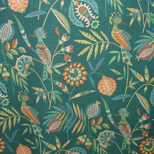 Könnte beinhalten: Tealfarbener Stoff mit einem sich wiederholenden Muster aus stilisierten Vögeln, Blumen und Blättern in Orange-, Gelb-, Grün- und Blautönen.