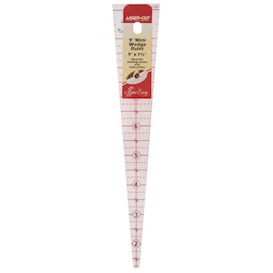 May include: A clear plastic 9-inch mini wedge ruler with red markings. The ruler is ideal for making circles and semi-circles. The ruler is labeled "Laser-Cut for Precision" and "Sew Easy".