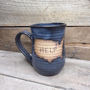 May include: A set of three ceramic mugs with a speckled, matte finish. The mugs are in shades of cream, light gray, and dark gray. Each mug has a simple, minimalist design and a rounded handle.